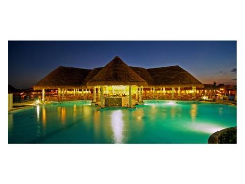 Palapa iluminada alrededor de la alberca