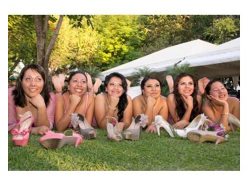 Novia y damas recostadas en el cesped