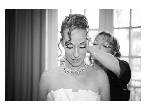 Madre de la novia ayudándola mientras se arregla.