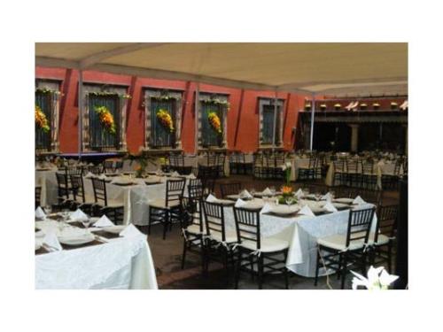 Montaje de mesas cuadradas bajo la carpa