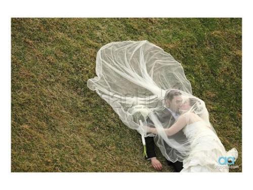 Novios recostados con velo