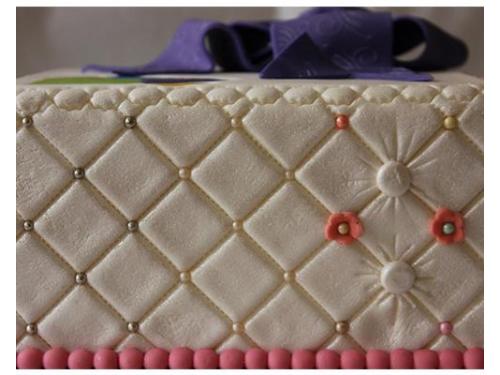 Pastel de fondant blanco con detalles rosas