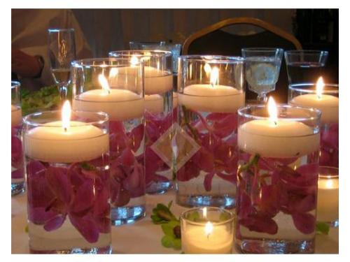 Velas flotantes con flores en cilindro de cristal