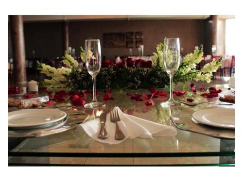 Mesa con copas y pétalos de rosa