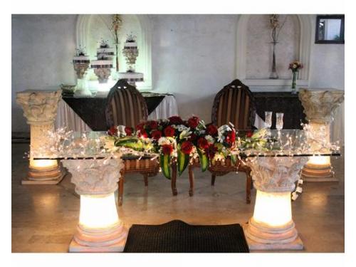 Iluminación y arreglo floral en la mesa de los novios