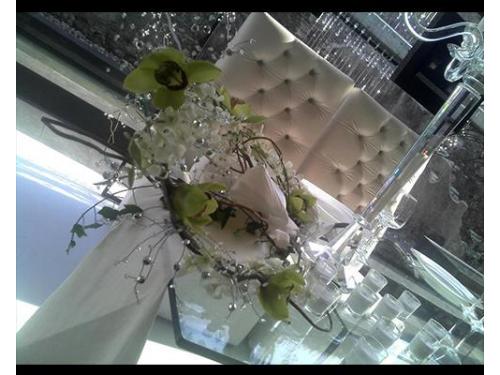 Sillón, arreglos de flores y velas en mesa principal