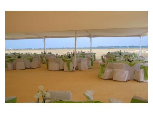 Carpa y mesas en la arena